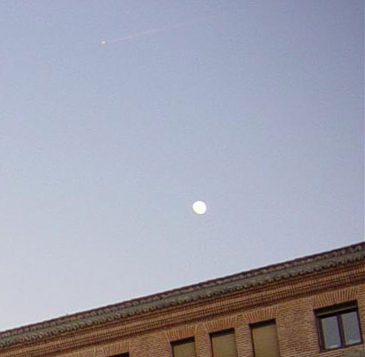 Point lumineux avec tra&icirc;n&eacute;e au-dessus de la lune